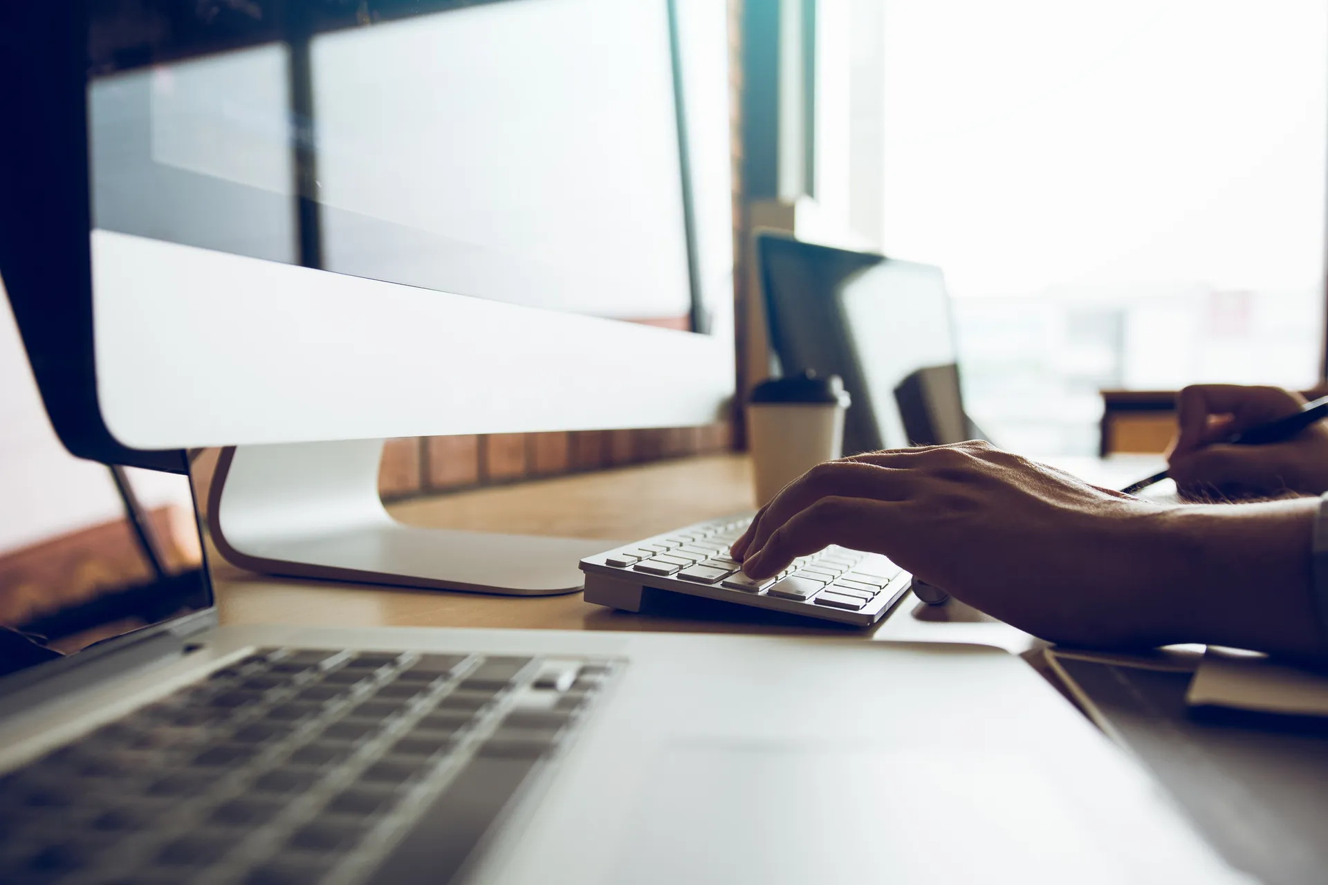 Mains tapant sur un clavier d'ordinateur portable, ambiance de travail concentré
